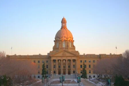 The Alberta Legislature Building in Edmonton at sunset, seat of the government whose voter-list rules the Alberta NDP is challenging