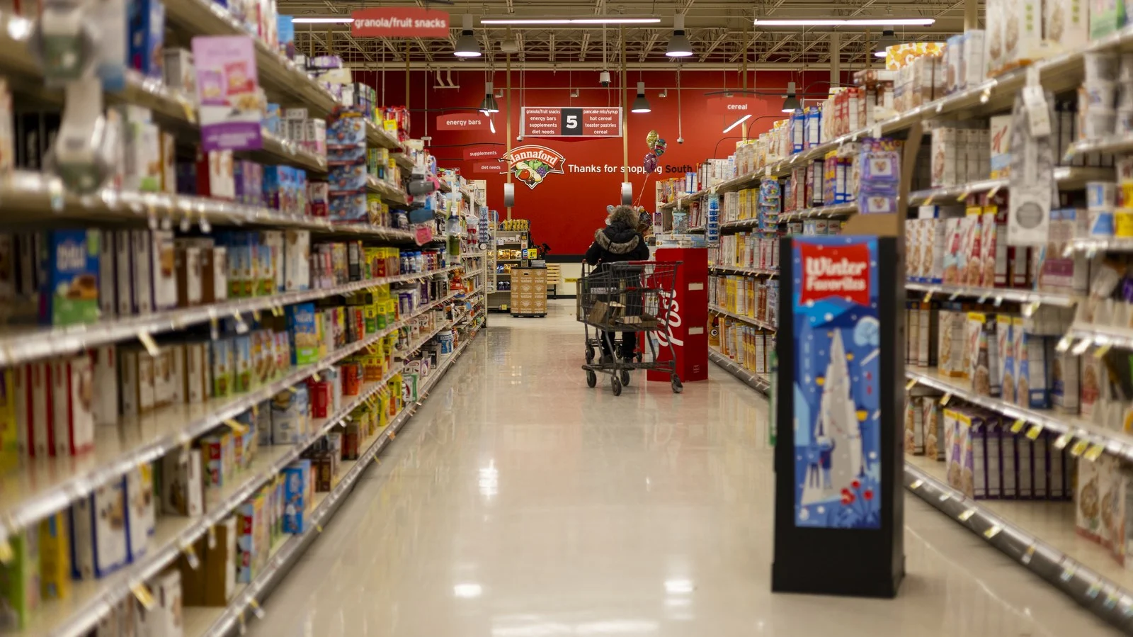 Competition Bureau Empire Grocery Deal 2026 — Sobeys Owner Agrees To Scrap Anti-Competition Property Controls 1 Stocked grocery store aisle, the kind of shelves at stake in the Competition Bureau Empire grocery deal on property controls