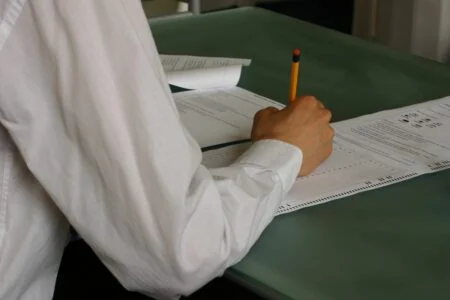 Students writing an English exam in a classroom