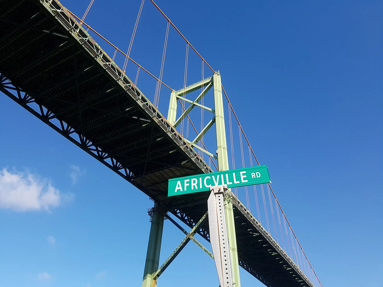 Nova Scotia Mackay Bridge Replacement Study 2026 — Repair, Rebuild Or Tunnel For Halifax Harbour? 2 MacKay Bridge replacement: Looking up at the MacKay Bridge deck and green tower from Africville Road in Halifax