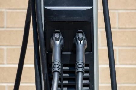 Nova Scotia Ev Levy 2026 — $500 Fee Takes Effect October 1 Close-up of electric vehicle charging station connector handles subject to the new Nova Scotia EV Levy