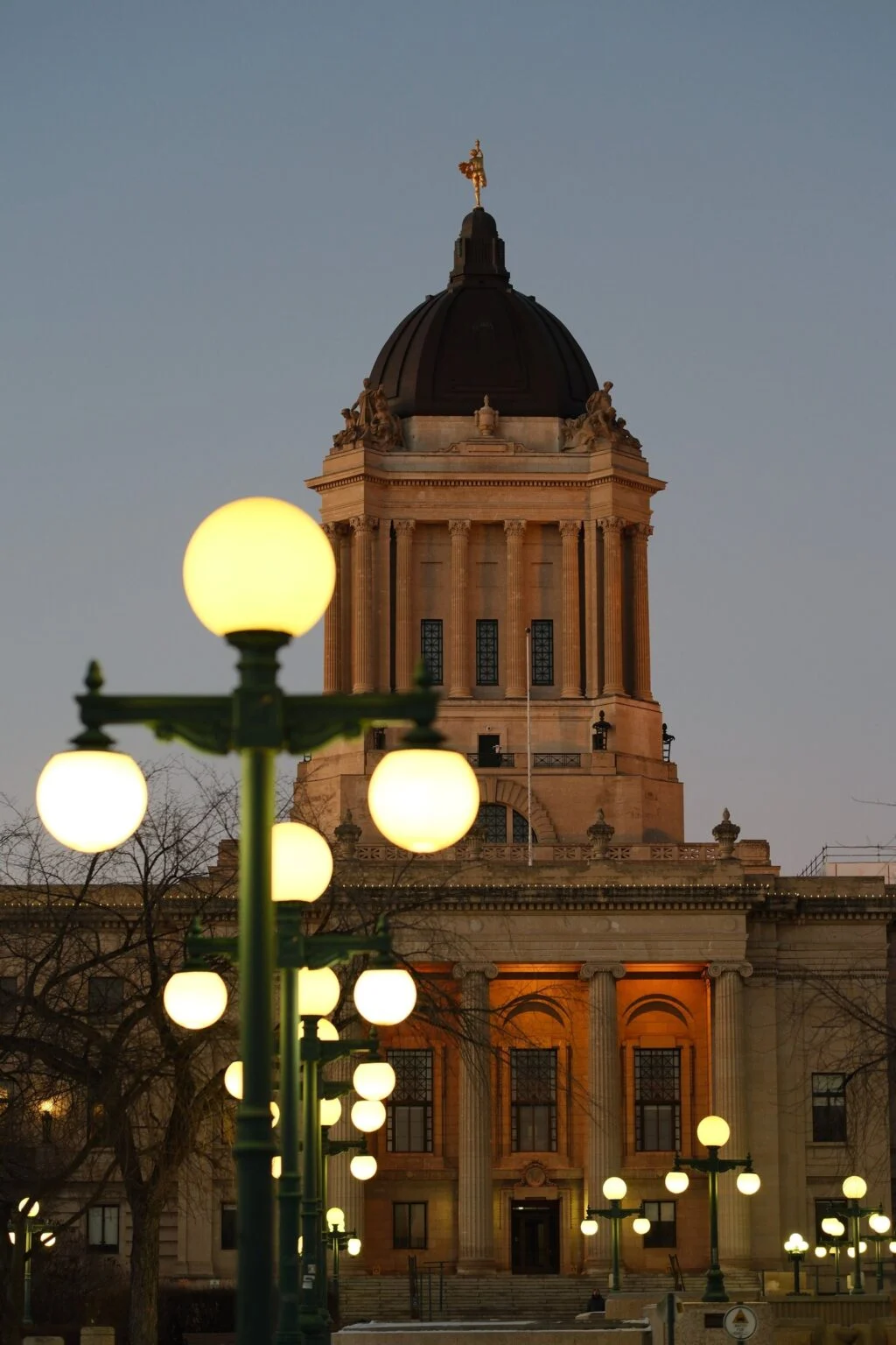 Manitoba Legislature building at dusk as Obby Khan resigns as PC leader