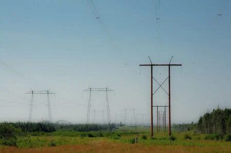 Point Lepreau Shutdown Heavy Water Leak 2026 — 200 Litres Lost, Plant Down Again Power lines at the Point Lepreau nuclear station site during the Point Lepreau Shutdown Heavy Water Leak outage
