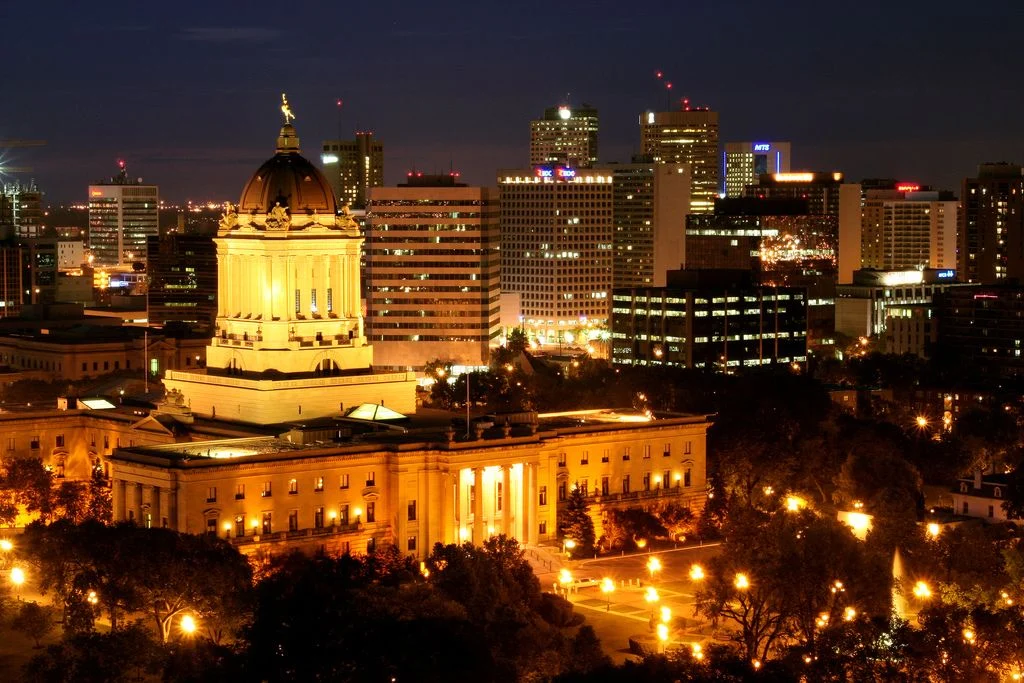 Health Ministers Meeting 2026 — Winnipeg Hosts Provinces As Ottawa Extends $1.2B In Mental Health Funding The Manitoba Legislative Building lit up at night in Winnipeg, host city of the Health Ministers Meeting 2026